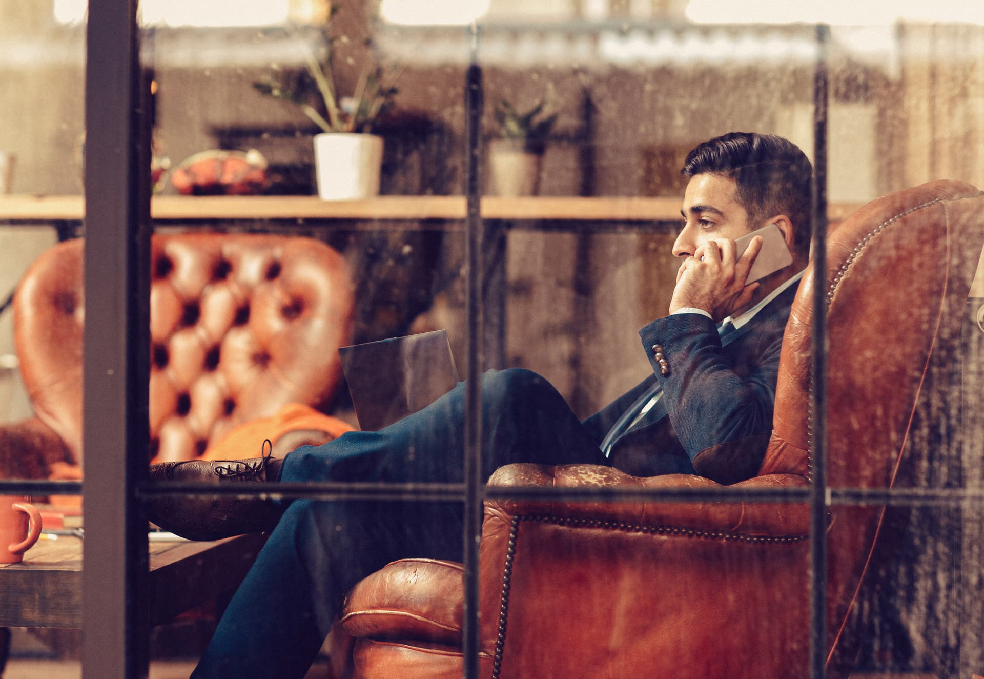 Successful businessman sitting in firm. Side view on man talking on phone. Professional activity. Advising. Counseling. Trading.
